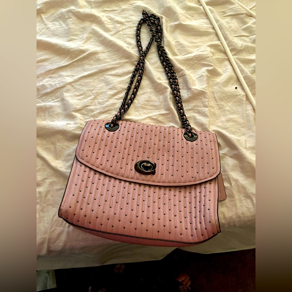 Coach purse with metal studs and braided pink and metal strap.